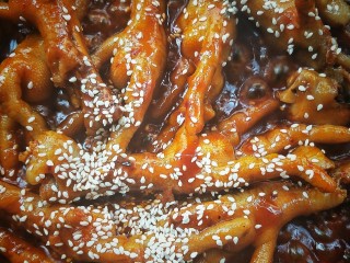21、入口即化的韩式辣鸡爪,关火,撒炒香的白芝麻,充分拌匀。