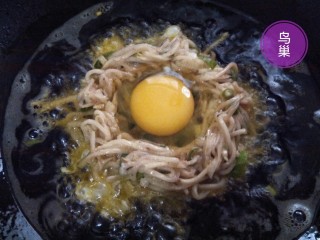 10、土豆鸟巢,油热即可把一半土豆丝拌料倒入油锅，用筷子轻轻拨动，在土豆丝中央拨出一个鸡蛋大小的凹坑区。磕一枚鸡蛋，将整个蛋清蛋黄轻放凹坑内。
