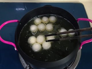 7、干菜炒汤圆,把汤圆用筷子挨个放入,并用筷子不断翻拌,以防粘连