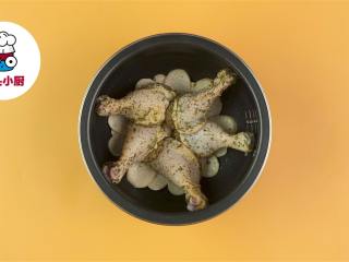 4、电饭煲香草烤鸡腿,电饭煲刷油，铺入杏鲍菇片，放上鸡腿，放入电饭煲，按煮饭键煮10分钟