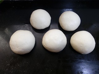 9、原味贝果（超详细版）,取一块切割后的面团，用光滑的一面去包住分割时的碎块，在面团的底部捏紧捏实，有点像们平时包包子的那样。