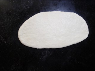 11、原味贝果（超详细版）,.松弛好的面团擀成椭圆形，用手尽力拍掉气泡。擀面的时候不要太用力，光滑的一面在上面，这样整形好的贝果表皮才不会裂开。 这时如果面团擀不开，就需要再松弛一会儿。尽量不要去硬擀开。