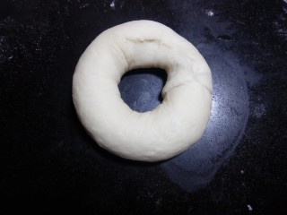 19、原味贝果（超详细版）,剪五张比圆环稍大的油纸(因为等下煮的时候方便拿取，不会粘在烤盘上，而破坏了整好的形状。)把整型好的面团放在油纸上，再整理一下圆环的形状，保证中间孔洞不要太小。