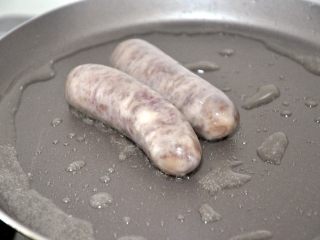 11、香肠吐司披萨,现在来准备披萨馅料,平底锅中倒入少量油,小火煎香肠,我用的珍妮珍馐的秘制原味纯肉香肠,不含淀粉,小朋友很喜欢。