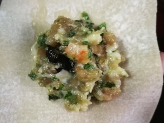 21、开洋香菇荠菜大馄饨,夹起肉馅放在皮子中央。