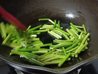 11、蒜苔炒腊肠,倒入蒜薹快速翻炒均匀制蒜苔起皱。
