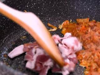 4、网红火山饭——在嘴里可以滚好几圈!,将辣白菜推至一边，下五花肉炒至焦黄