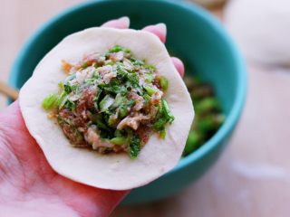 13、小苔菜虾皮花样包子,在面皮里放入适量的馅料。