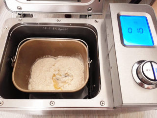 1、海陆至尊披萨,把中筋面粉，盐，糖，酵母放入面包机里，和面成团，