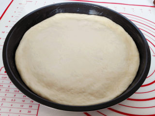 7、海陆至尊披萨,将擀好的面皮放入披萨盘内，用手按压面皮，把面皮撑至与盘子同样大，边缘挤出一圈圆边，