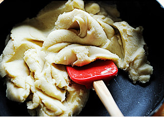 6、白莲蛋黄月饼,炒到水份基本蒸发后分三四次加油，每次加油都要炒到莲蓉完全吸入油，最后加入糖炒干，如图一般，取出室温降温，放冰箱冷藏一夜。