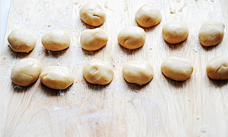 9、白莲蛋黄月饼,转化糖浆加枧水搅匀，加花生油搅匀，最后加入面粉拌匀成团，裹保鲜膜放入冰箱冷藏1小时后取出，分成13g一个的面剂，用保鲜膜盖上防止皴裂；