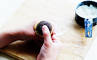 11、白莲蛋黄月饼,面皮略微压扁，放在虎口处，中间放入馅，右手拇指与食指扶住皮和馅，左手虎口处慢慢向上推，将面皮包住整个馅；