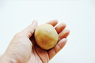 14、白莲蛋黄月饼,将包好的月饼轻轻搓成椭圆，滚一层手粉，然后在手心来回晃动几下，散去多余的手粉；