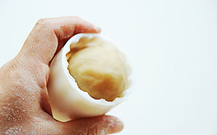 15、白莲蛋黄月饼,将月饼胚子滚成长椭圆，放进月饼模子里，在撒了薄薄的面粉的案板上用力压模具，然后提起；