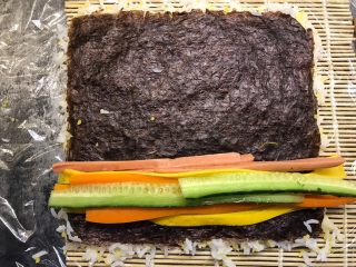 14、肉松寿司,依次把黄瓜、胡萝卜、香肠、鸡蛋条铺上去