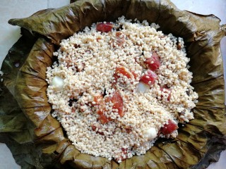 10、荷叶糯米排骨饭,然后把糯米和排骨倒进铺好荷叶的蒸笼里