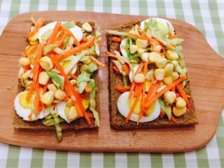 9、花样三明治,在把剩下的卷心菜，胡萝卜，玉米粒铺在熟鸡蛋片上面。