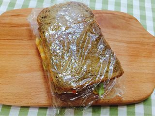 10、花样三明治,另外一片吐司盖在上面，用保鲜膜卷起来轻轻压平。