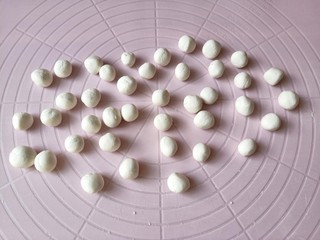4、油炸汤圆,取一个剂子包上豆沙馅放手心揉成圆形。