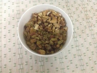 2、自制夹心圆面包,在第一次发面完成后,将核桃碎和葡萄干加入面团。再次启动面包机的发面程序。