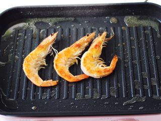7、蒜香海虾炒芦笋,把海虾煎至两面金黄色，并且煎出虾油后，盛出备用。