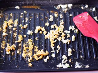 8、蒜香海虾炒芦笋,利用锅里煎海虾的油，爆香大蒜末。