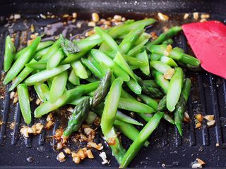 10、蒜香海虾炒芦笋,锅中加入焯过水的芦笋，继续翻炒均匀。