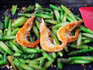 15、蒜香海虾炒芦笋,加入煎好的海虾。