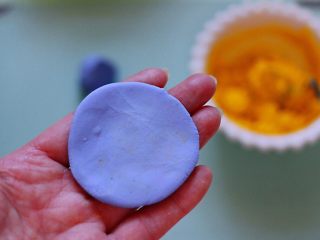 8、星空水晶奶黄汤圆,取一个剂子用手压成薄薄的面饼。
