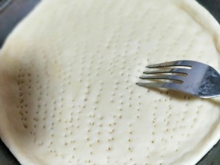 19、做饼＋咖喱香菇鸡丁披萨饼,用叉子扎满洞洞，防止饼皮烤的过程中，中间凸起。放入烤箱进行二次发酵约15分钟左右。