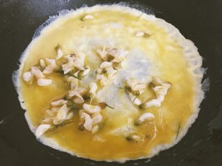 7、洋槐花厚蛋烧,倒入少量蛋液，待稍微凝固，即可卷起来