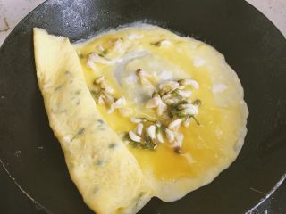 8、洋槐花厚蛋烧,继续倒蛋液，等凝固再卷起