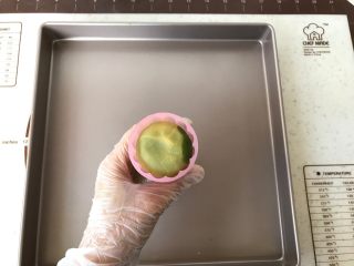 6、桃山皮月饼,放入事先装好花片的月饼模内，轻轻先压扁一下