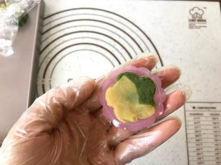8、桃山皮月饼,如果是相色，如做一些花朵造型的，先将取小面团直接按压在花片的花朵造形上，边缘用牙签进一步勾勒一下去掉造形毛边
