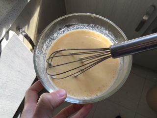 16、日式泡芙蛋糕卷,将牛奶分次倒入蛋糊中，边倒边搅拌，搅拌成均匀的蛋奶液