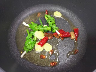 4、胡萝卜炖牛腩,炒锅内倒适量的食用油烧热,下入小葱结、姜片、干红辣椒、八角和桂皮炒香。