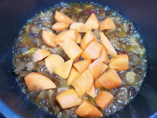 12、胡萝卜炖牛腩,先下入胡萝卜翻炒均匀,炖2分钟。