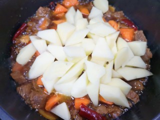 13、胡萝卜炖牛腩,再下入土豆块翻炒均匀。