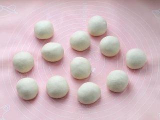 9、紫米面包,取出面团按压排气，分成均匀的12个小面团，滚圆覆盖保鲜膜松弛20分钟。
