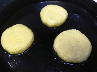 13、黄金玉米饼,放入平底锅中，轻轻按扁，饼之间留点距离。