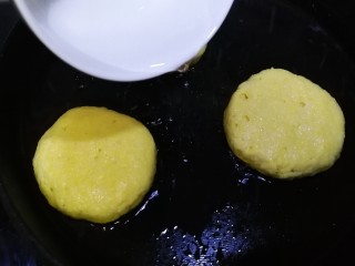 14、黄金玉米饼,中小火煎2分钟，底部上色，放入少半碗清水。