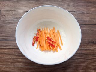 11、泰式柠檬酸辣鸡爪,冰镇鸡爪时间里，胡萝卜切成丝、小米辣切成段放入碗中。（也可以根据自己的喜欢，添加黄瓜之类）