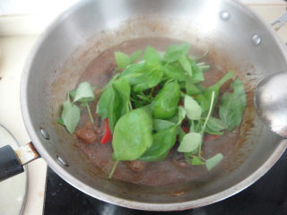 12、罗勒烧鸡腿,加入罗勒叶煸炒均匀后熄火出锅