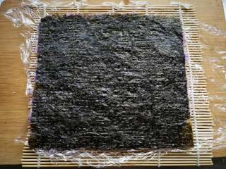 6、翻转花朵寿司,翻过来,保鲜膜一面朝下。