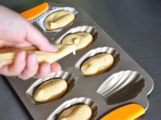 13、焦糖玛德琳,模具涂抹上一层脱模油挤入面糊至八分满。