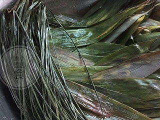 2、咸蛋肉粽子,粽子叶和粽子绳子也需要提前浸泡，浸泡时间跟腌制瘦肉差不多，浸泡好用剪刀剪去粽叶蒂，用毛巾两面擦洗干净，再用清水洗几遍就干净了。