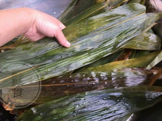 5、咸蛋肉粽子,材料全部准备好了就可以包了，拿两张粽叶一边头一边尾一边高一边低摆放，然后两边往中间卷起来。