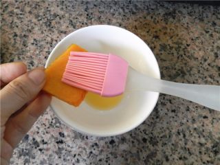 5、蜂蜜烤南瓜,用硅胶刷沾些黄油，依次刷在南瓜片上，不用很多，薄薄一层即可。