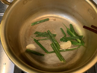 13、韩式泡菜豆腐汤,放入准备好的葱段和蒜，中小火翻炒出味道